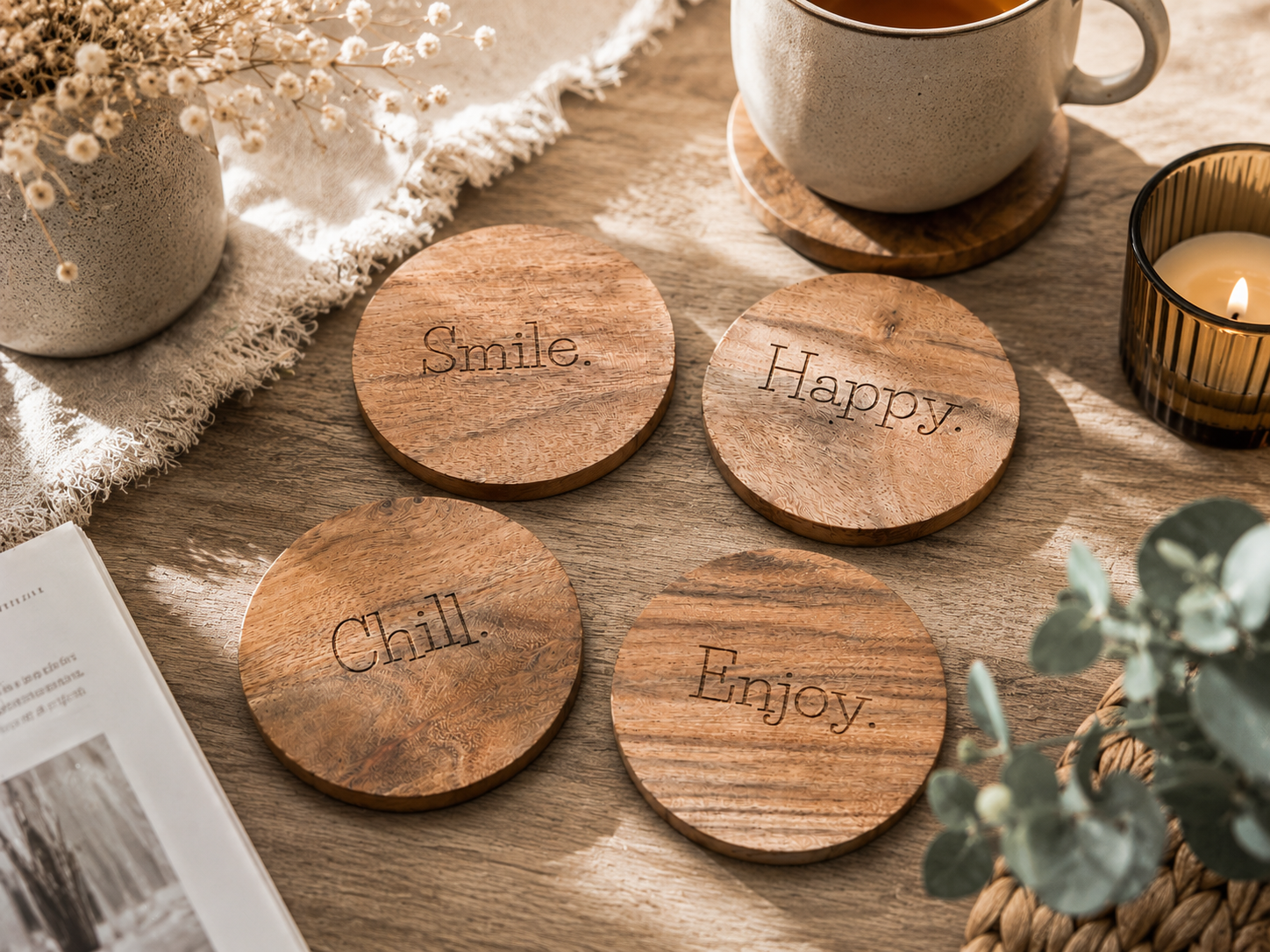Lot de quatre sous-verres en bois gravés Smile, Happy, Chill et Enjoy, disposés sur une table en bois dans une ambiance chaleureuse et naturelle.