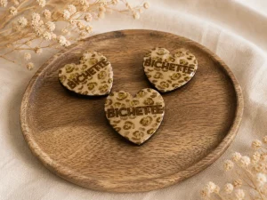 Broches décoratives dorées présentées sur un plateau en bois