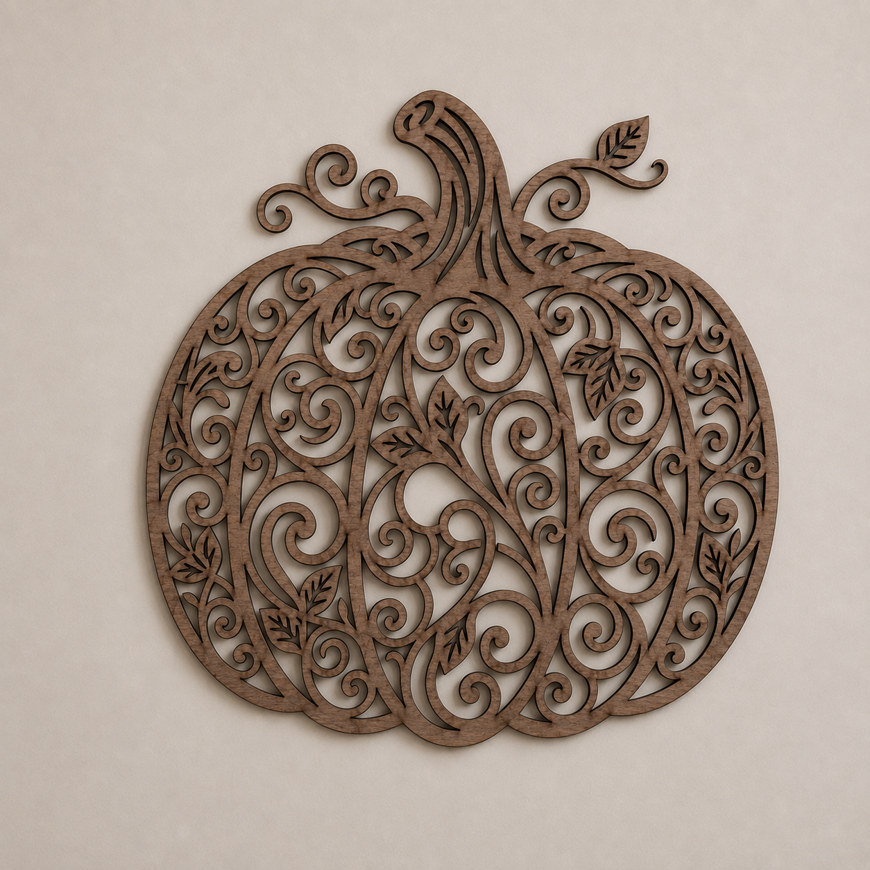 Décoration murale en bois représentant une citrouille ajourée avec des motifs végétaux et des volutes